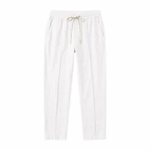 Flat lay of white cotton linen loose straight trousers with drawstring elastic waist