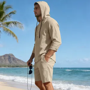 Men's casual beige linen set featuring hooded henley shirt and shorts on a sunny beach
