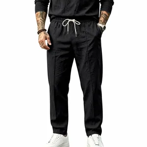 Front view of black cotton linen drawstring pants on model with relaxed straight fit