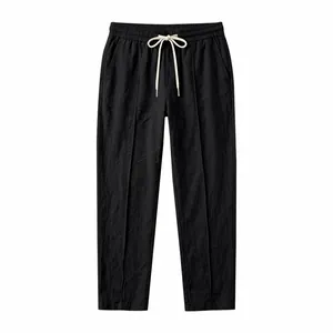 Detail view of black cotton linen pants with drawstring waist and vertical seam detail