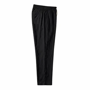 Close-up side view of black cotton linen loose-fit trousers with drawstring waist