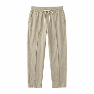 Detailed macro shot of beige cotton linen straight trousers featuring a drawstring waist
