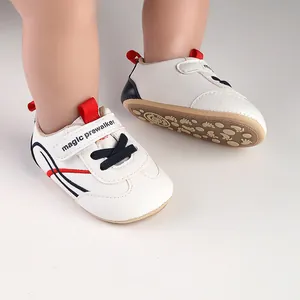 Detail of white baby pre-walker shoes with soft anti-slip soles and red accents