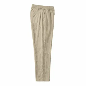 Close-up of khaki cotton linen trousers featuring elastic drawstring waistband texture