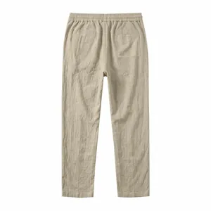 Back view of relaxed fit beige cotton linen straight leg pants for summer vacation styling.