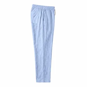 Side profile of light blue linen straight-leg trousers with elastic waistband detail
