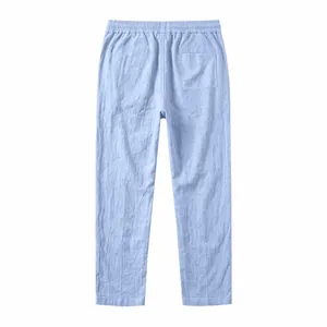 Back view of light blue linen straight-leg trousers with elastic waist and back pocket.