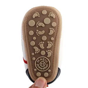 Close-up of non-slip baby shoe sole with cute footprint pattern and magic prewalker logo