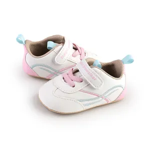 Side detail of soft-sole baby pre-walker shoes in white with pink accents