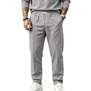 Detailed view of men's loose cotton linen trousers in grey with drawstring waist