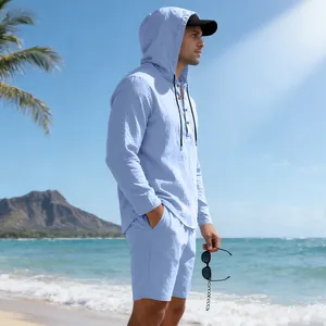 Close-up detail of a men's light blue linen hooded long-sleeve Henley shirt on beach