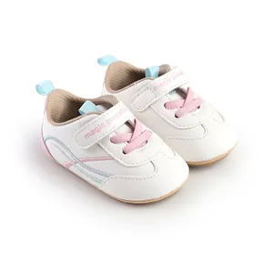 Close-up view of white baby pre-walker shoes featuring pink laces and velcro straps