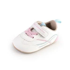 Close-up of white baby walking shoe with pink Velcro strap and soft sole design