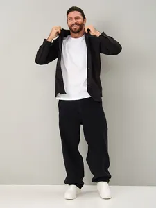 Macro view of men's loose straight-leg black jeans styled with a casual shirt on a fashion model
