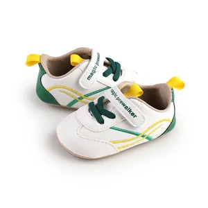 Detailed view of white baby prewalker shoes with green accents and velcro strap