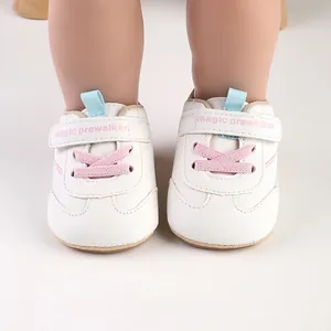 Front detail view of white baby prewalker shoes with pink laces and velcro straps
