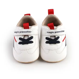 Macro view of white soft-soled baby pre-walker shoes with magic prewalker straps.