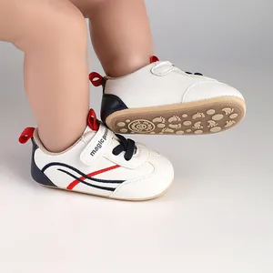 Detail view of white baby pre-walker shoes with navy accents and non-slip patterned sole