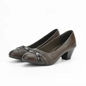 Close-up of brown mid-heel pumps for women with elegant decorative straps on the toe