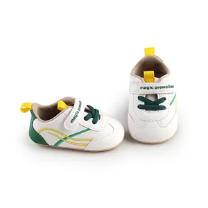 Side and front view of white baby pre-walker shoes with green and yellow accents