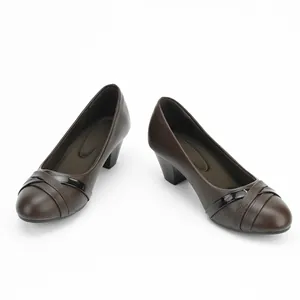 Detailed macro view of brown women's block heel pumps with elegant crossover straps