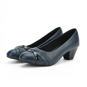 Detail view of navy blue leather pumps with chunky mid-heel and cross strap design.