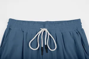 Close-up of blue corduroy trouser waistband with white drawstring and elastic design.