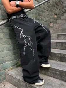 Vaqueros vintage negros lavados para hombre con un estampado gráfico de rayo blanco