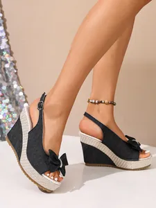 Detailansicht stilvoller Denim-Keilsandalen mit Schleife und gewebter Plateausohle