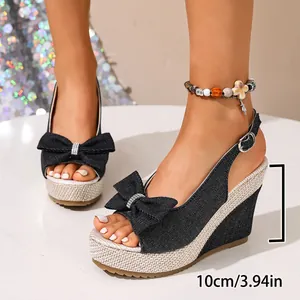 Seitenansicht der schwarzen Keilsandaletten aus Denim mit 10 cm Absatz und Schleife