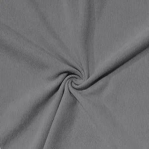 Gros plan sur la texture du tissu en velours côtelé gris pour l'ensemble polo d'été