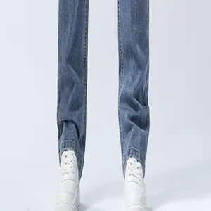 Close-up detail of men's straight leg blue denim jeans paired with white sneakers