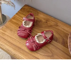 Detail of red Mary Jane shoes with bowknot and delicate lace trim for girls