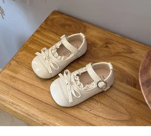 Detail of cream girls Mary Jane shoes featuring delicate lace trim and ribbon bow