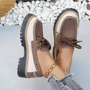 Primer plano de mocasines con plataforma en marrón y beige con cordones y suelas gruesas