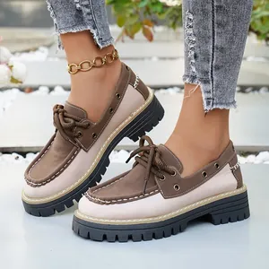 Detalle de mocasines con plataforma retro con suelas gruesas y diseño bicolor con cordones