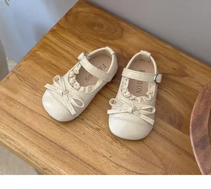 Detailed view of cream girls Mary Jane flats featuring lace trim and a delicate bow detail