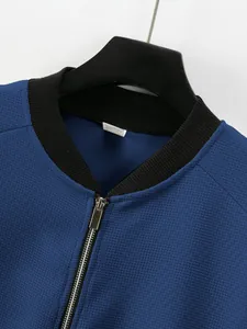 Close-up of blue waffle knit jacket featuring a ribbed collar and silver metal zipper