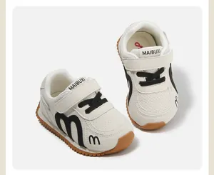 Detail of white children's fashion sneakers with black accents and soft brown sole