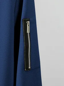 Detailed view of blue waffle-knit texture and zipper sleeve pocket on men's winter jacket