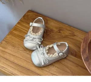 Close-up detail of silver girls Mary Jane shoes with delicate lace trim and bow.