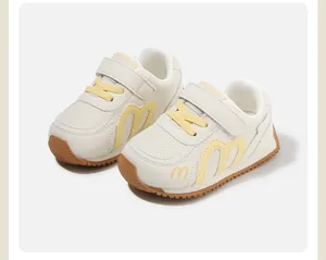 Close-up of children's cream sneakers with yellow accents and soft rubber soles