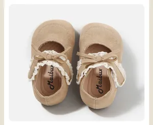 Overhead view of elegant tan suede baby girl walking shoes with lace and bowtie detail