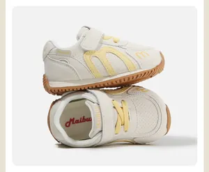 Detailed view of cream and yellow toddler sneakers with soft non-slip soles.