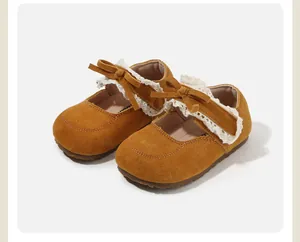 Detailed view of yellow suede baby walking shoes with white lace trim and bow accent