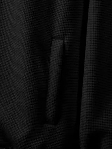 Detailed close-up showing black waffle knit fabric texture and side pocket of men's jacket