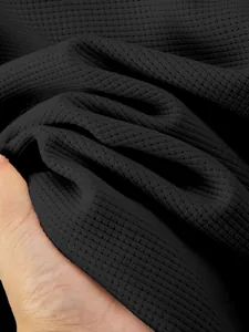 Macro detail showing the premium black waffle knit fabric texture for men's winter jacket