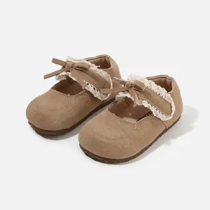 Elegant toddler girl walking shoes featuring a cute bow and lace trim in soft tan suede finish