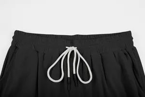 Close-up of black corduroy trousers waist with adjustable white drawstring design