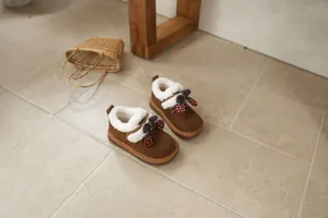 Cozy brown children's snow boots with white fleece lining and decorative cherry charms.